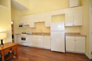 怀尔顿水景湾酒店的厨房配有白色橱柜和白色冰箱。