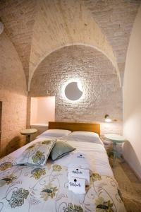 阿尔贝罗贝洛Petra Suite的一间卧室设有一张带石墙的大床