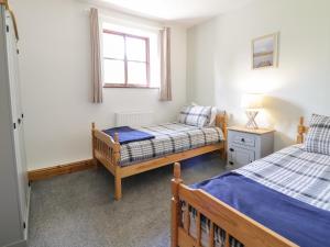 巴拉Cyffdy Cottage - Arenig的一间卧室设有两张床和窗户。