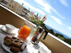 阿尔盖罗Voce Del Mare - sea view- Alghero Airport的一张桌子,早餐包括橙汁和饼干