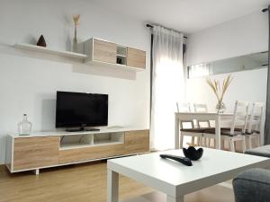 圣费尔南多Apartamentos Coralba - El Escondite de la Bahía的客厅配有电视和白色桌子。
