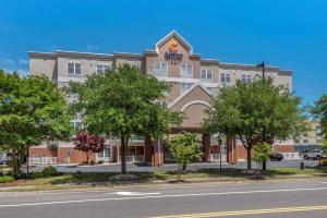 弗吉尼亚海滩Comfort Inn & Suites Virginia Beach - Norfolk Airport的街道前有树木的办公楼