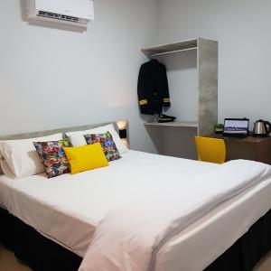 乌贝兰迪亚Aero Inn Hotel的卧室配有一张带黄色枕头的大型白色床。