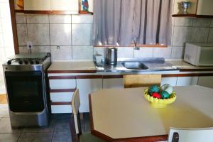 巴拉那州蓬塔尔Apartamento Beira Mar的厨房配有一张桌子,上面放着一碗水果