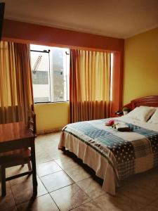 哈恩Hotel el León de Oro的一间卧室配有一张床、一张书桌和一个窗户。