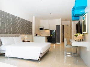 马尼拉City Park Hotel Residences的一间带白色大床的卧室和一间厨房
