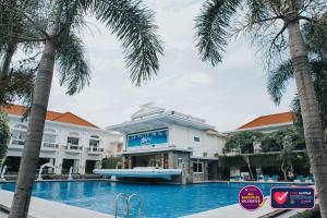 梭罗阿迪旺萨酒店的一座拥有游泳池和棕榈树的酒店