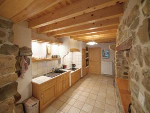 MontarcherGîte Montarcher, 4 pièces, 6 personnes - FR-1-496-11的厨房配有木制橱柜和石墙