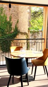 圣西普里安Hotel-Restaurant des Augustins - Cosy Places by CC - Proche Sarlat的阳台配有桌椅