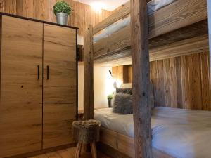 埃尔瓦尔德Chalet Apart Hansler的一间卧室配有一张双层床和木墙