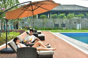 南京南京溧水中山湖金陵文璟酒店的坐在伞下沙发上的男人和女人