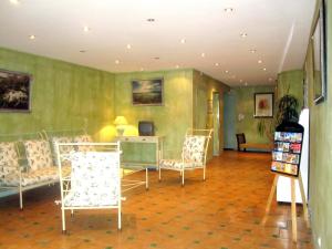 穆斯捷-圣玛丽伯恩奥伯格酒店的客厅配有椅子、桌子和书桌