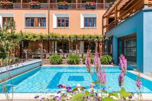 施伦斯蒙塔弗纳霍夫酒店的一座紫色花卉建筑前的游泳池