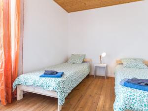 Saint-ViaudGîte Saint-Viaud, 3 pièces, 4 personnes - FR-1-306-1190的一间卧室设有两张床,铺有木地板