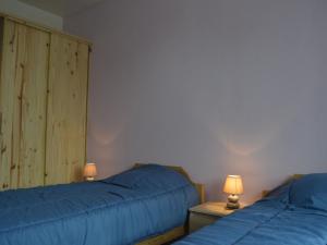 MontipouretGîte Montipouret, 3 pièces, 4 personnes - FR-1-591-190的卧室内的两张床,配有蓝色的床单和灯具