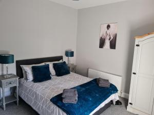 多尼戈尔AMY'S Place Charming 3 Bed House Donegal的一间卧室配有一张带蓝色枕头的床