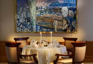 圣莫里茨水晶酒店的餐厅的一张桌子,墙上挂着一幅画