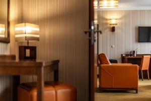 梅尔诺Dworek Morski SPA & Wellness的酒店客房配有橙色椅子和书桌