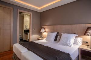 巴利亚多利德华盛顿帕克索尔套房酒店的卧室配有一张带白色床单和枕头的大床。