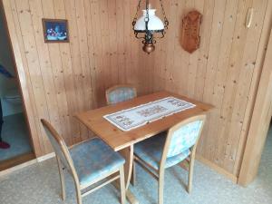 布里恩茨2 Zimmerwohnung Homestay Brienz Spanischgässli的一张木桌,配有两把椅子和一盏灯
