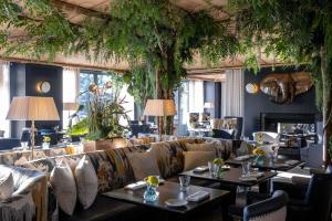 日内瓦日内瓦保护区温泉酒店的餐厅配有沙发、桌子和植物