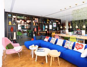 楠泰尔巴黎拉德芳斯世民酒店 的客厅配有蓝色的沙发和椅子