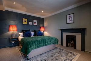 斯托昂泽沃尔德贝尔和斯图尔特之家宾馆的一间卧室设有一张绿色的床和一个壁炉