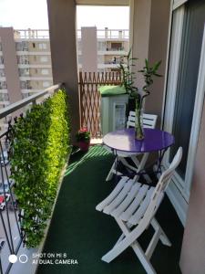 马赛appartement marseille velodrome的阳台配有紫色的桌椅