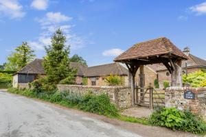 布莱顿霍夫Dyke Farm Barn near Brighton by Huluki Sussex Stays的石头房子,设有木门和围栏