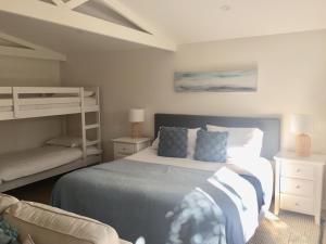 FreshwaterBijoux Beach House的一间卧室配有一张床和一张双层床。