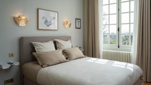 艾镇Les Chambres du Champagne Collery的一间卧室配有一张带白色床单的床和一扇窗户。