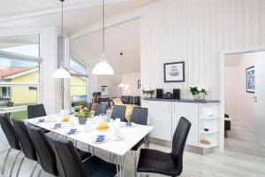 格罗森布罗德Resort 2 Ferienhaus Typ D 122的一间配备有白色桌子和黑色椅子的用餐室
