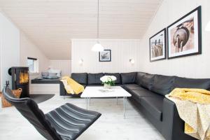 格罗森布罗德Resort 2 Ferienhaus Typ D 122的客厅配有黑色真皮沙发和桌子