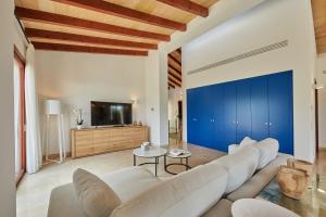 坎亚梅尔Villa Jade by Cap Vermell Estate的客厅配有白色家具和蓝色的墙壁