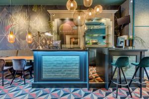 阿姆斯特丹亚历山大酒店的餐厅设有蓝色酒吧,配有椅子和桌子