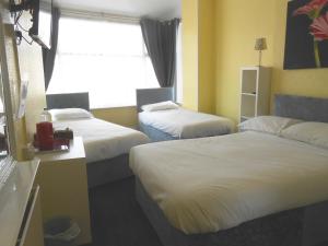 布莱克浦Shore Stay Guest House的酒店客房设有两张床和窗户。