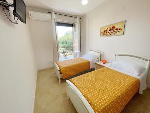 卡斯特拉玛雷帝斯达比亚Flavia Apartment的客房设有两张床、一台电视和一扇窗户。