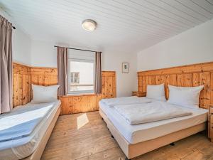 蒂罗尔-基希贝格Chalet Kirchberg的一间卧室设有两张床和窗户。
