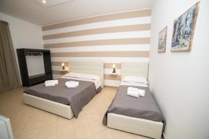 阿沃拉b&b Zio Luciano的一间卧室设有两张床和条纹墙