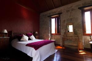 特罗尔Casa Rural Las Caldereras的一间卧室配有一张带紫色床单的大床