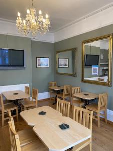 朴次茅斯Waverley Park Lodge的一间带桌椅和吊灯的用餐室