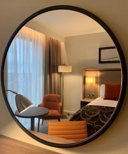 曼彻斯特Clayton Hotel Manchester City Centre的酒店客房,配有床和圆镜子