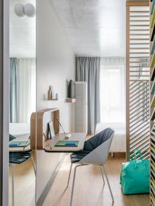 尼斯OKKO Hotels Nice Aéroport的客房设有书桌、椅子和床。
