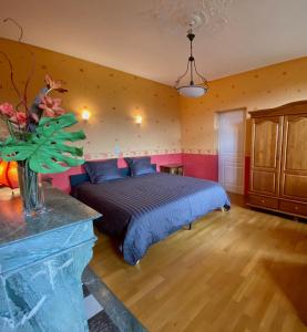 米尔库尔Chambre Hôte Villa Sainte Barbe的带壁炉的客房内的一间卧室配有一张床