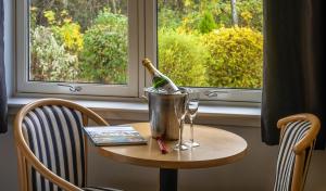戴斯Pinehurst Lodge Hotel - Aberdeen的一张桌子,上面放着一瓶葡萄酒和一桶