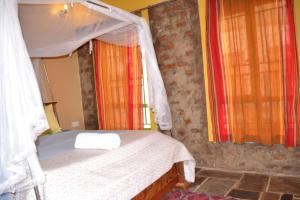 KisoroMondi Lodge Kisoro的一间小卧室,配有一张带天蓬的床