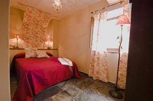 Seares拉斯里拉民宿的一间卧室设有红色的床和砖墙