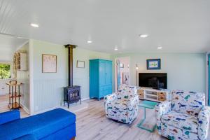 布莱恩Seaview Cottage的客厅配有两把椅子和蓝色沙发
