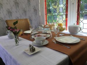 圣塞沃兰Manoir de L'Epine的一张带白色桌布的桌子和一张带盘子和眼镜的桌子