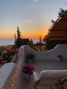 帕奥拉Vista Stromboli的露台上的日落美景,庭院里摆放着椅子和鲜花